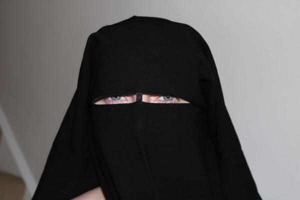 Femme niqab posant nue avec des talons hauts à lanières