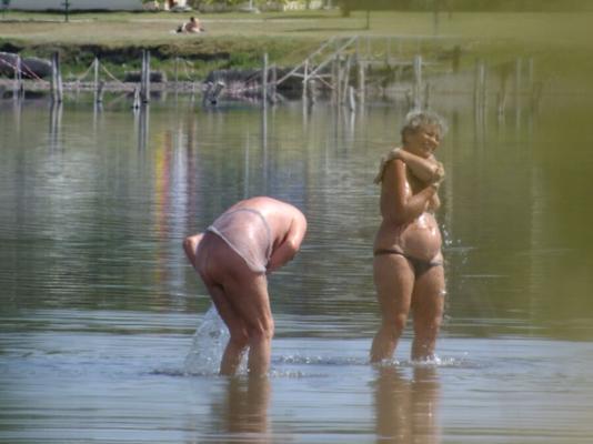 Alte Dame am Strand, die den Bikini wechselt. 